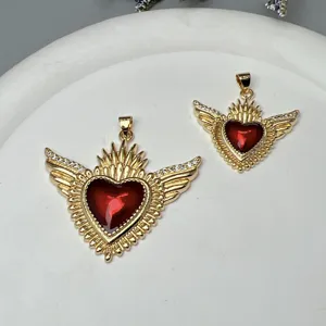 Gros plan détaillé du pendentif aile cœur rouge doré, accessoire de bijoux couronne émaillée.