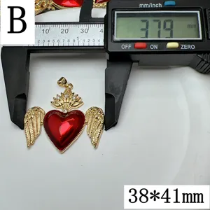 Vue détaillée du pendentif cœur aile émail rouge avec couronne et accessoire de bijouterie.