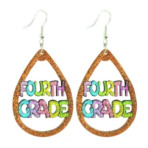 Close-up detail of the glittery teardrop earrings featuring colorful cutout fourth grade letters.