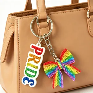 Colorful glitter rainbow bow and pride letter bag charm keychain set for trendy accessories.
