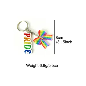 Detailed close-up view of colorful rainbow glitter bow and PRIDE letter keychain accessory.