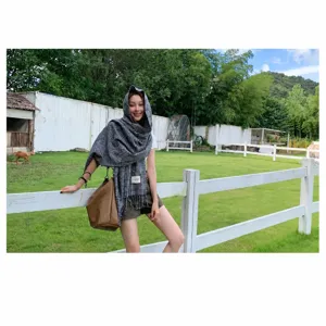 Detailed view of the classic black and white plaid scarf, showcasing the soft fabric and tassels.