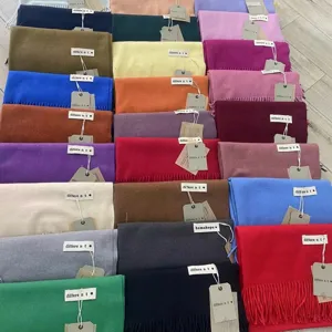 Vue détaillée d'écharpes d'hiver unies et colorées avec franges, montrant la belle texture.