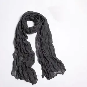 Detail shot of a dark grey crinkled solid color scarf, lightweight voile wrap for women.