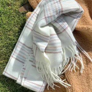 Detail view of a cozy white plaid scarf with fringe, soft imitation cashmere fabric.