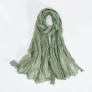 Detailed view of a sage green crinkled voile scarf, soft sheer fabric texture closeup.
