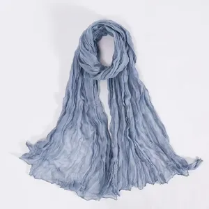 Close-up detail of the lightweight crinkled voile scarf texture in elegant blue shade.