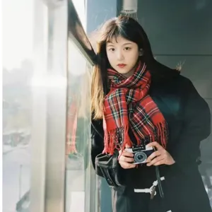 Detailed view of the winter warm red plaid scarf with classic fringe design in lifestyle.
