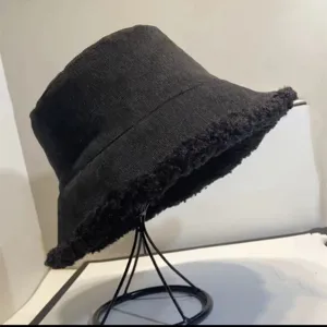 Close-up view of black corduroy bucket hat with soft plush sherpa fleece brim trim.