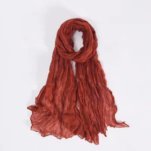 Detailed view of a solid rust red crinkled balisoz scarf, lightweight draped wrap for women.