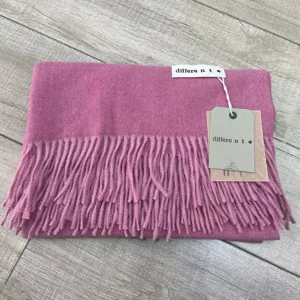 Gros plan détail d'un écharpe d'hiver douillette à franges, texture douce avec étiquette.