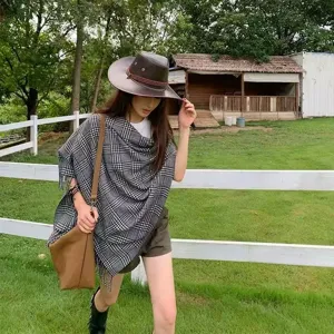 Classic black and white plaid women poncho scarf, warm autumn winter outdoor fashion style.