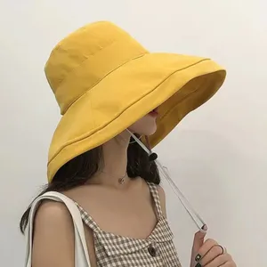 Stylish yellow wide-brim bucket hat for women, soft peach skin fabric, perfect outdoor sun hat.