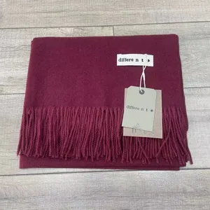 Détail d'écharpe d'hiver unie, tissu doux au toucher cachemire avec franges et étiquette.