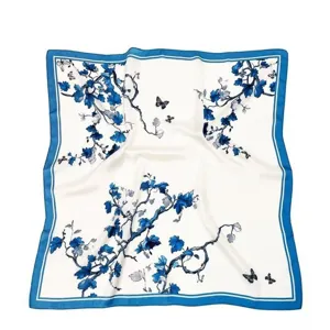 Detailed view of the blue and white floral silk scarf with elegant butterfly prints and borders.