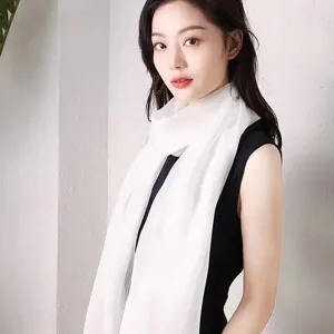Vue détaillée d'un foulard châle long et léger, blanc uni et doux, porté par un mannequin.