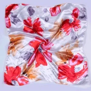 Detail view of a satin floral square scarf featuring vibrant red and grey flowers on white.