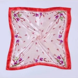 Detailed view of women printed silk square scarf with red border and floral design.
