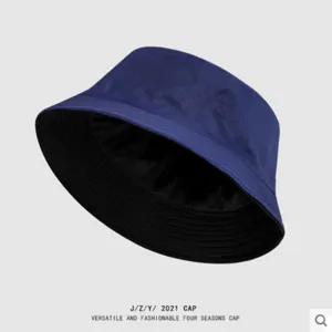 Detail view of a solid color reversible bucket hat, blue and black, sun protection summer cap.