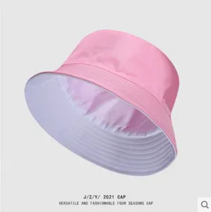 Detail view of the pink and white reversible bucket hat, showing soft fabric and neat stitching.