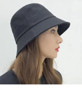 Side profile detail view of a black cotton bucket hat worn by model, simple casual style.