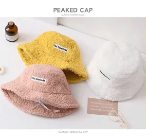Fluffy plush bucket hat detail showcasing warm winter fleece texture and embroidered label.