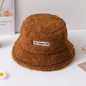 Brown plush bucket hat with cozy fleece texture and front label, warm winter daily wear.