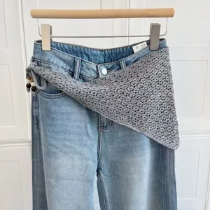 Jeans en denim bleu clair assorti d'une écharpe triangulaire en tricot gris pour femmes.