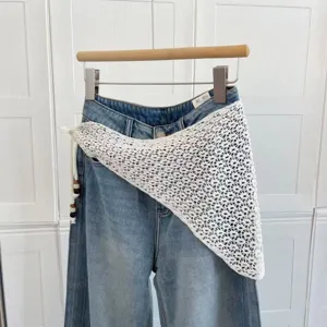 Détail d'écharpe triangulaire au crochet blanc, châle en maille ajourée avec franges.