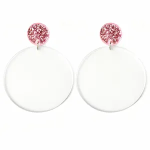 Close up of acrylic third grade earrings with glitter studs and colorful text design.