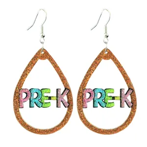 Close-up detail of glittery teardrop earrings with PRE-K cut-out letters and metal hooks.