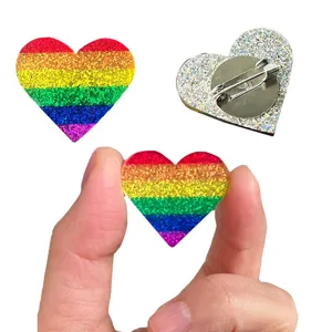 Vue détaillée de la broche cœur arc-en-ciel à paillettes colorées, montrant l'avant et l'arrière.