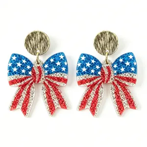 Close-up detail of US Independence Day bow earrings with sparkling glitter stars and stripes.