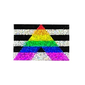Gros plan detail de la broche insigne triangulaire pailletee arc-en-ciel coloree.