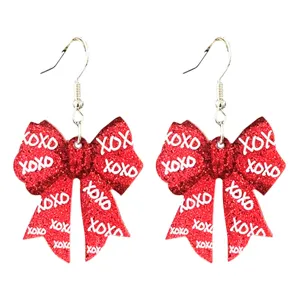 Boucles d'oreilles nœud pailleté rouge étincelant avec texte XOXO blanc bijoux saint valentin.