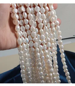 Close up detail view of natural freshwater baroque pearl strands, elegant glossy seedless pearls.