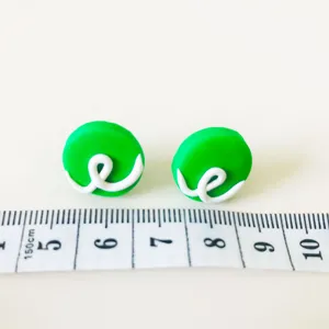 Grüne Polymer Ton Ohrringe Detailansicht mit Grösse und weisser Knotendekoration handgemacht.