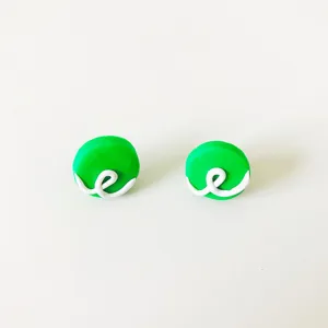 Nahaufnahme von handgefertigten grünen Polymer-Ton-Ohrringen mit weißem Wirbelmuster.