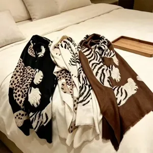 Elegant leopard and tiger print scarves, luxurious fashion accessories displayed on soft bed linen.
