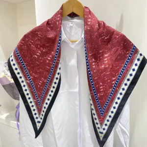 Primo piano della elegante sciarpa triangolare retrò, bordeaux con bordo a diamanti.