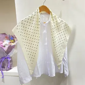 Foulard triangolare rétro a pois abbinato a una camicia bianca, elegante accessorio e sciarpa.