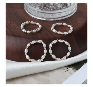Feine Detailaufnahme von stapelbaren Süßwasserperlen Ringen mit goldenen Perlen.