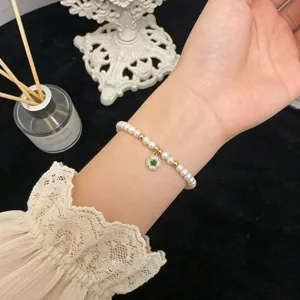 Elegant freshwater pearl bracelet featuring a clover pendant and delicate beads for women.