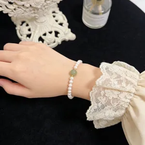 Natural freshwater pearl bracelet with green jade bead and gold accents elegant elastic jewelry