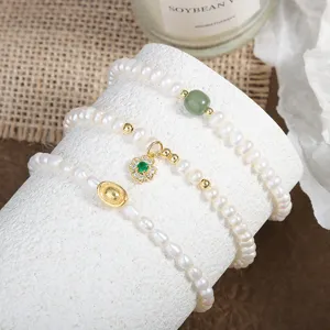 Detail shot of natural freshwater pearl bracelets featuring a clover pendant and jade bead.