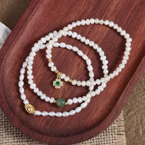 Detailed view of natural freshwater pearl bracelet featuring a clover charm, Hetian jade and ingot.
