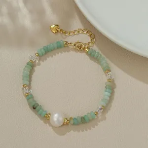 Detalle de pulsera de perlas barrocas, cuentas verdes coloridas con cadena dorada ajustable.