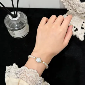 Natürliches Barockperlenarmband mit Sternanhänger und Goldperlen, Detailaufnahme.