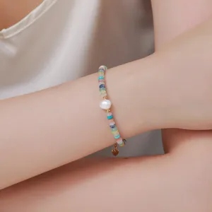 Detalle de pulsera de perlas barrocas de colores con cuentas multicolores y bonito colgante de corazón.