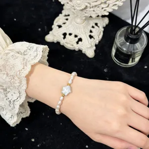 Nahaufnahme des Barockperlenarmbands am Handgelenk mit Sternperle und Goldperlen im edlen Stil.